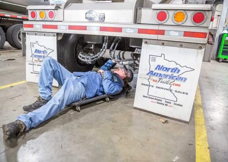 Person inspecting underneath a trailer
